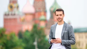 Ein Geschäftsmann am Rotem Platz neben Basilius Kirche in Moskau