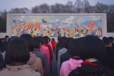 Kinder stehen vor einem Wandgemälde in Pjöngjang, Nordkorea.