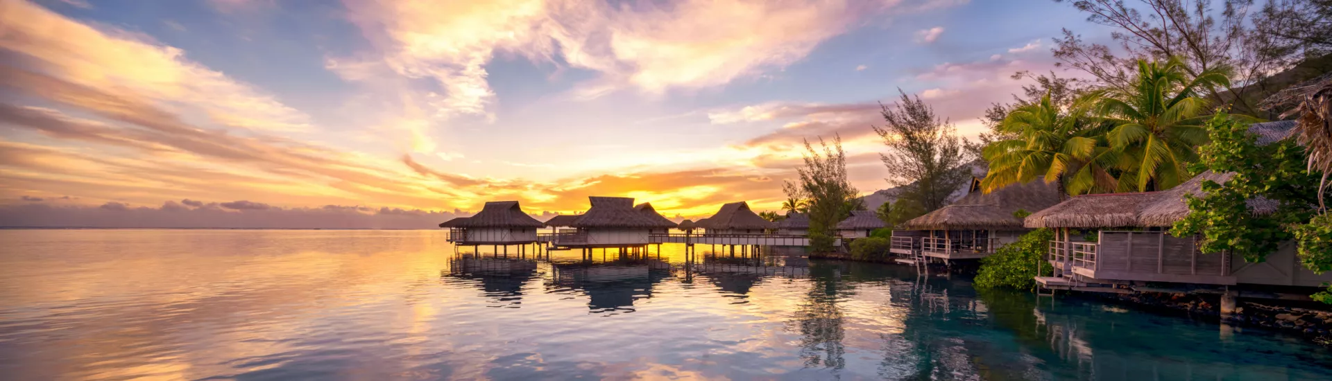 Sonnenuntergang mit orangefarbenem Himmel und Silhouette von Palmen auf den Malediven