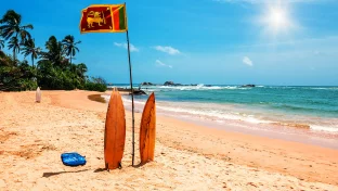 Surfbrett und Flagge von Sri Lanka am Strand