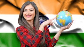 Eine junge Touristin hält einen Globus von Erde gegen eine Flagge von Indien