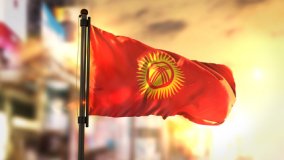 Flagge Kirgisistans weht bei Sonnenuntergang im Wind