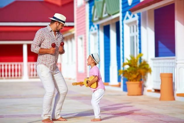 Vater und Sohn musizieren und tanzen freudig auf Kuba