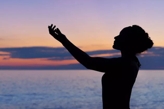 Frau macht Yoga mit Seeblick