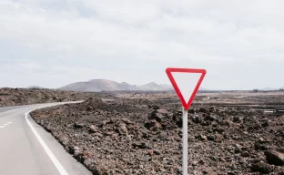 Warnschild in Wüstenlandschaft symbolisiert Reisewarnung für Niger