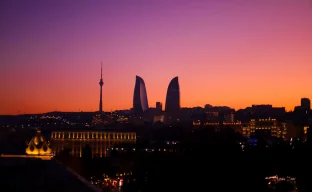a sunset view of a city with tall buildings