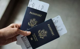 US-Reisepass mit Visa-Stempeln und Einreisedokumenten