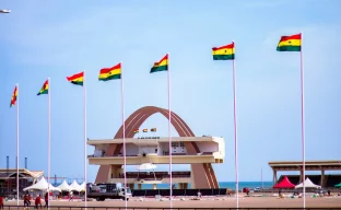 Ghanaische Flagge und Reisedokumente symbolisieren Visumantrag trotz Website-Ausfall