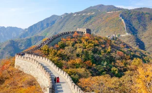 Zwei Touristen gehen auf einem Weg auf der Spitze der Chinesischen Mauer.