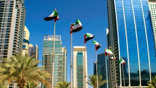 Blick auf Gebäude in Dubai mit Flaggen der Vereinigten Arabischen Emirate.