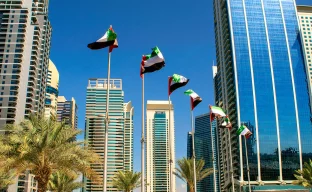 Blick auf Gebäude in Dubai mit Flaggen der Vereinigten Arabischen Emirate.